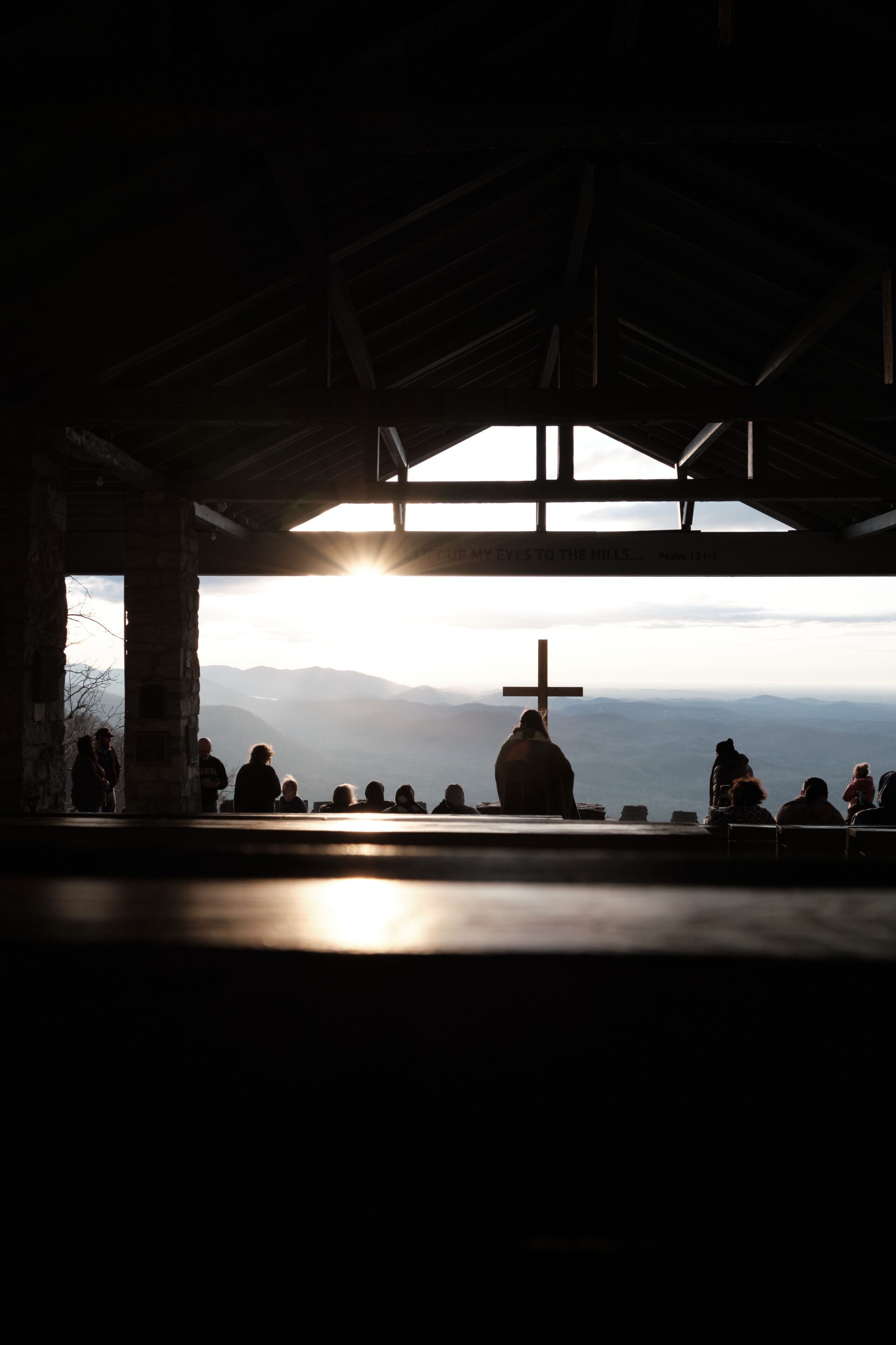 A serene silhouette of a cross during sunset, viewed from inside a church, captivating the peaceful atmosphere reflecting our Global Methodist Church Parker, CO community.