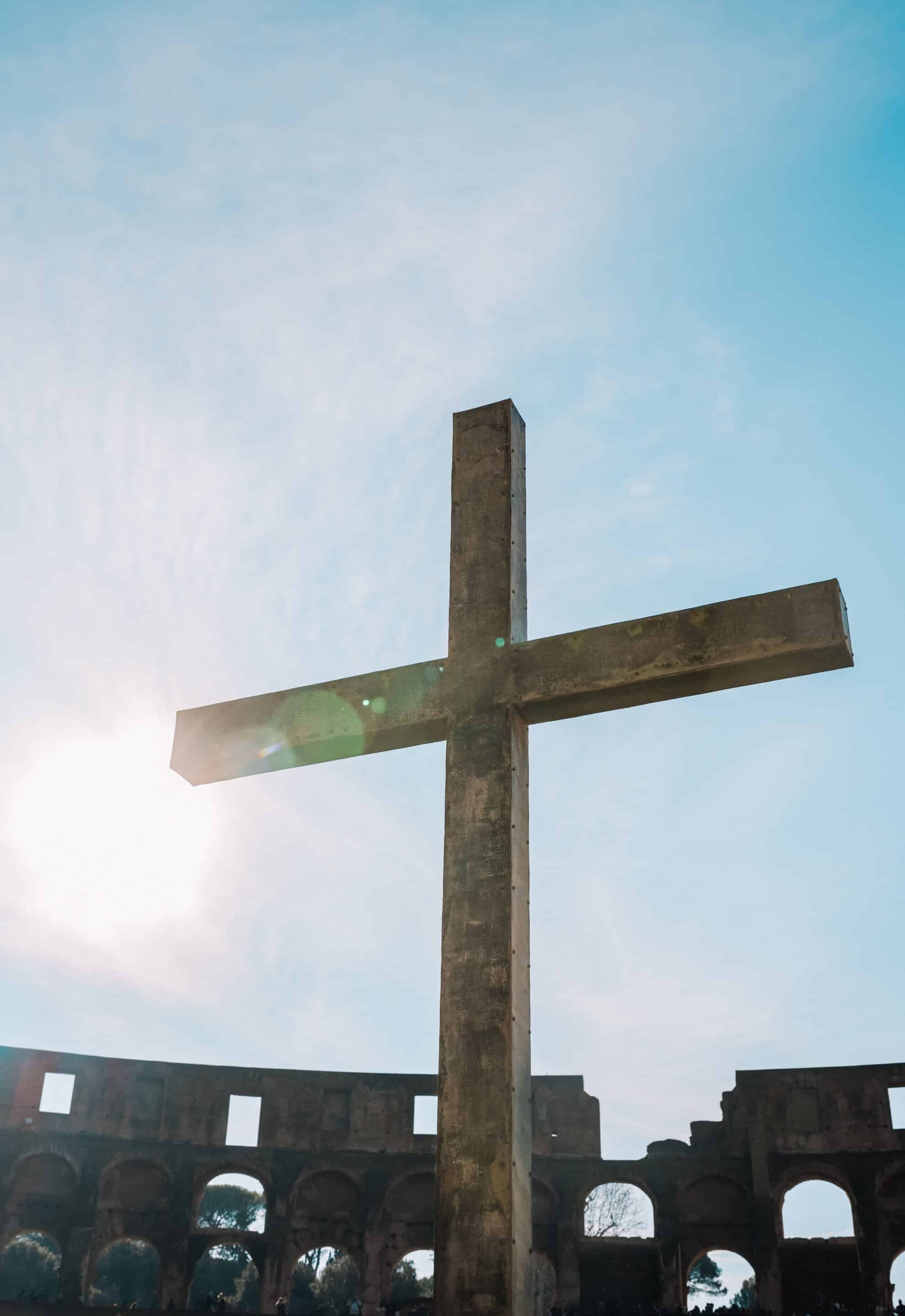 A striking cross stands with a bright sunlit sky as background reflecting our beliefs as a Wesleyan Church in Parker, CO.