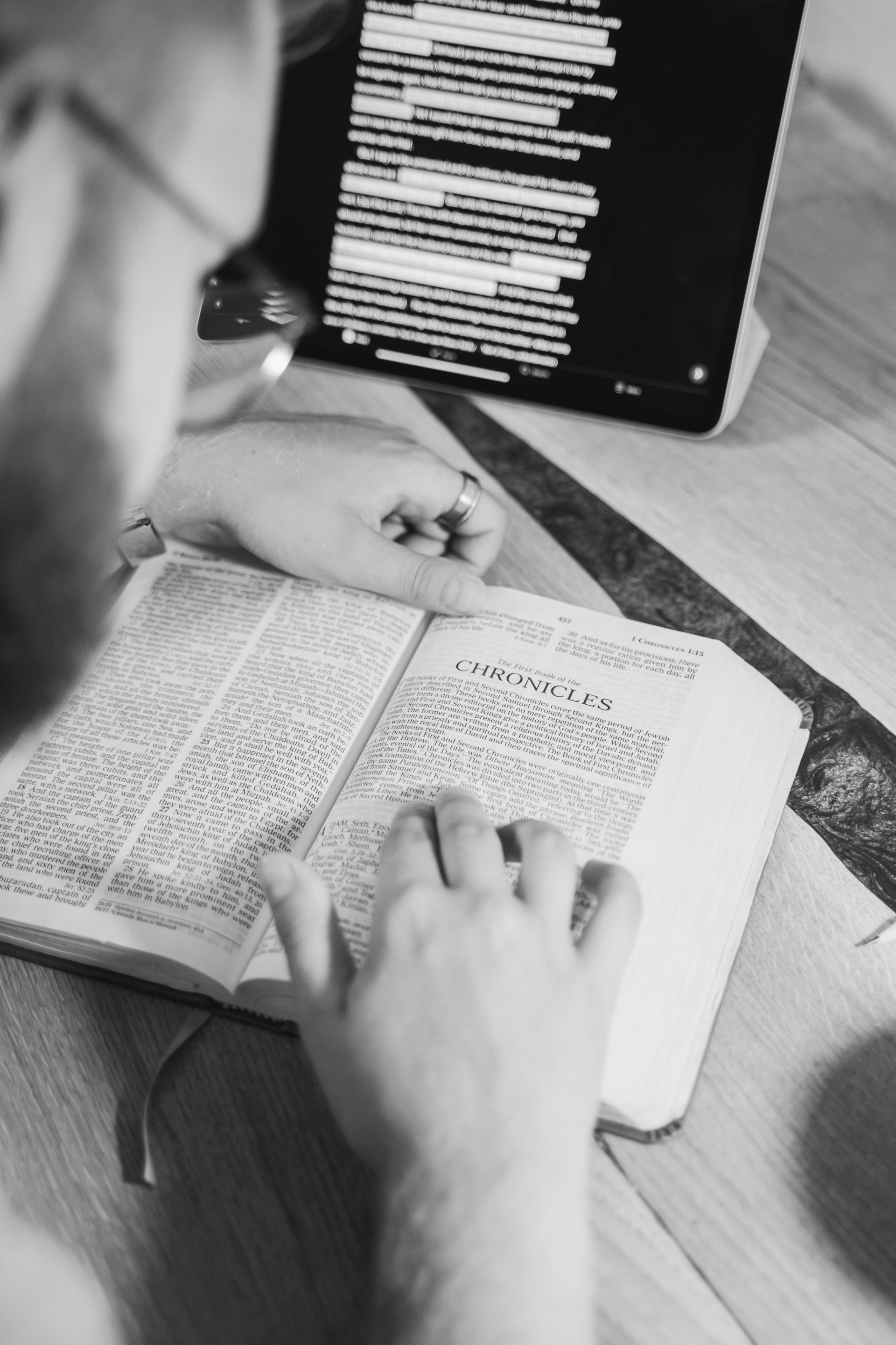 An open Bible with Chronicles being studied, accompanied by a digital tablet for reference reflecting our methodist membership information.